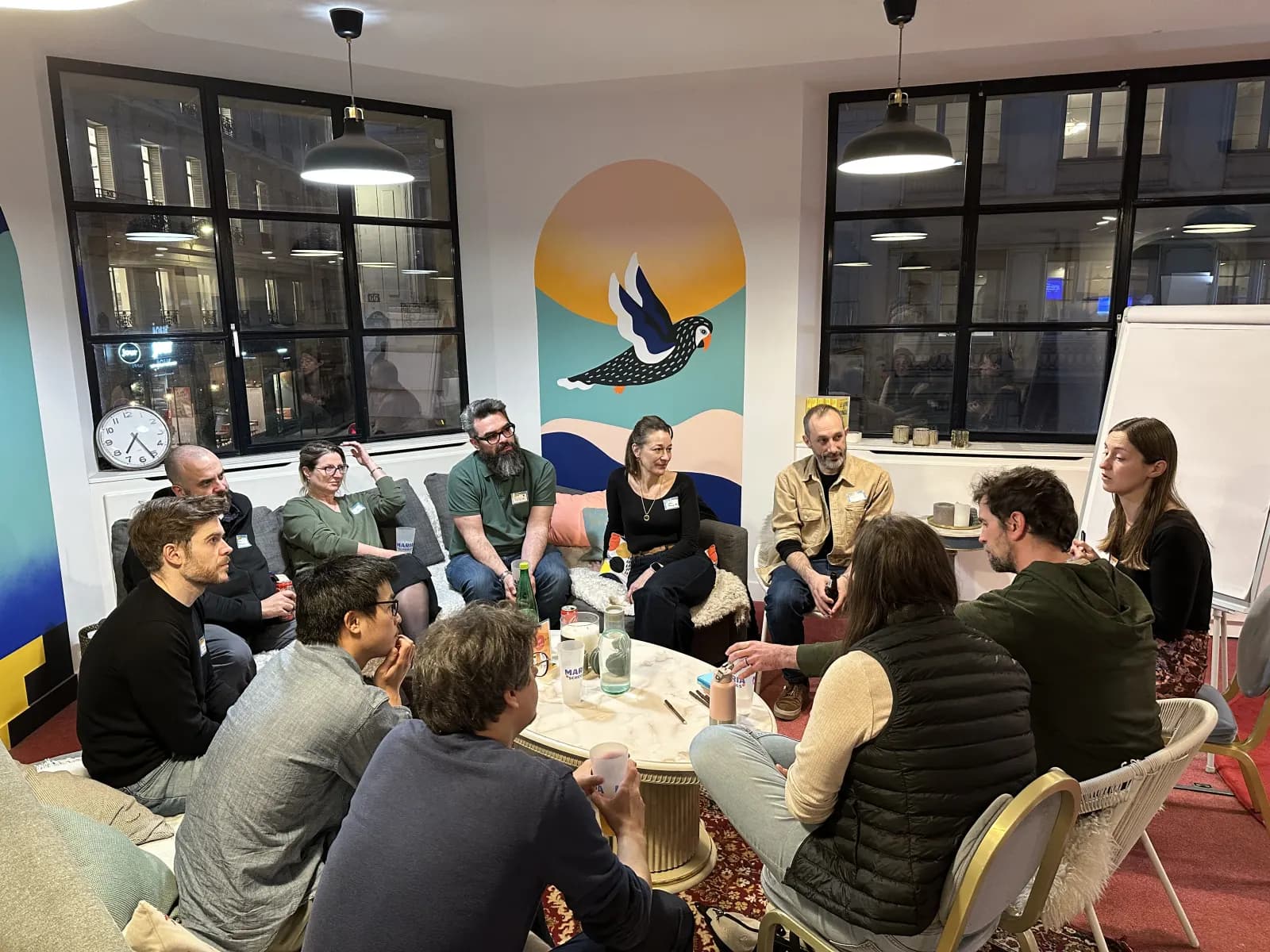 Une douzaine de participants en cercle dans des fauteuils, en pleine discussion