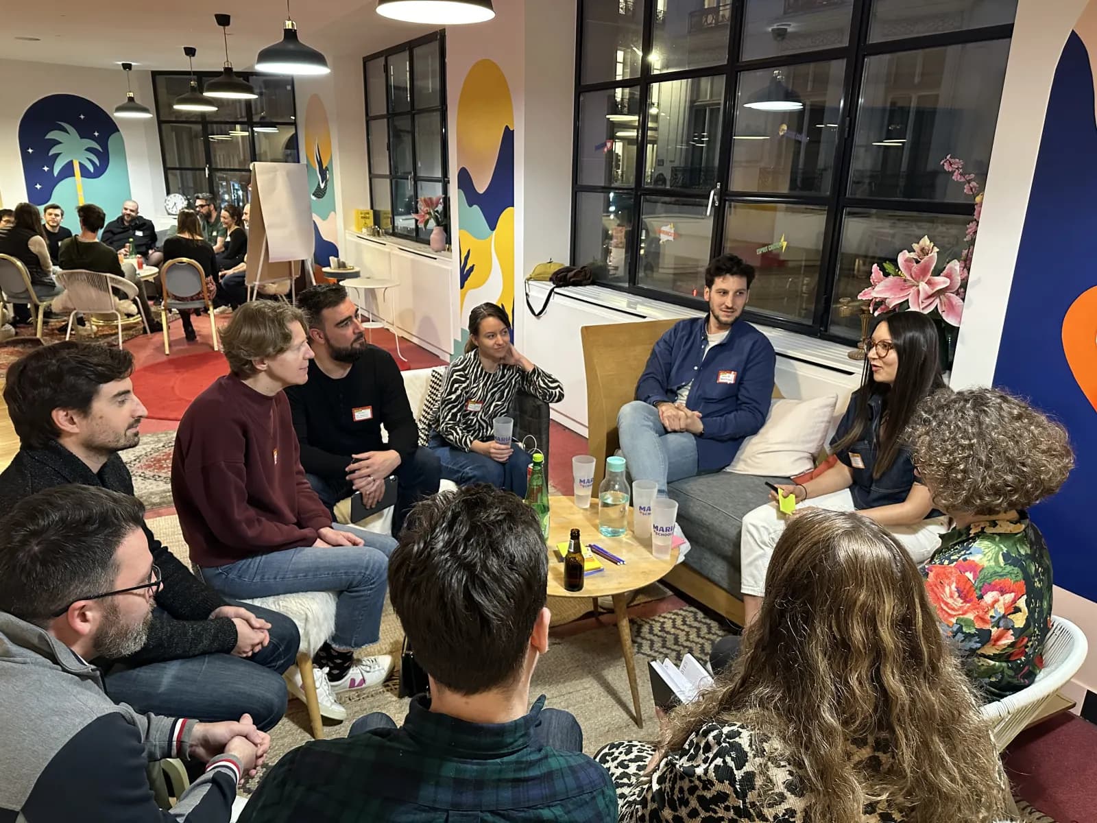 Des participants assis en cercle échangent autour d'une table basse
