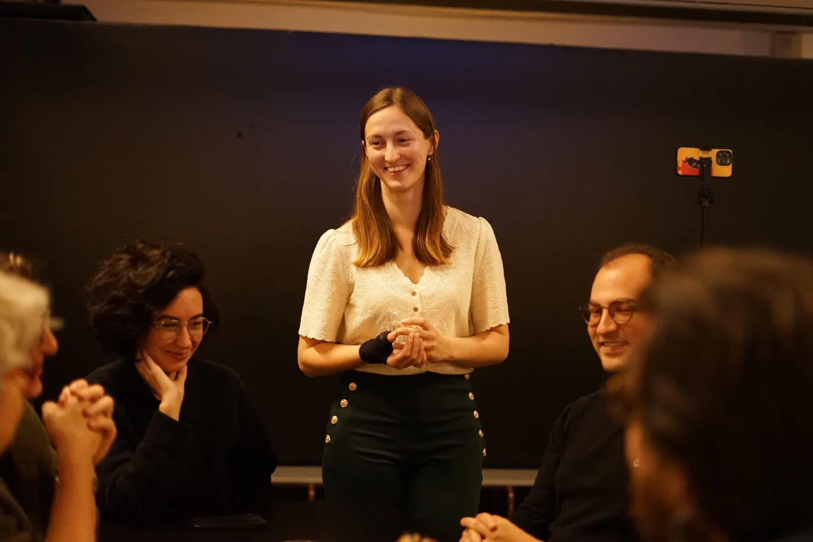 Une intervenante debout présente devant une table de participants souriants, à la rentrée 2025